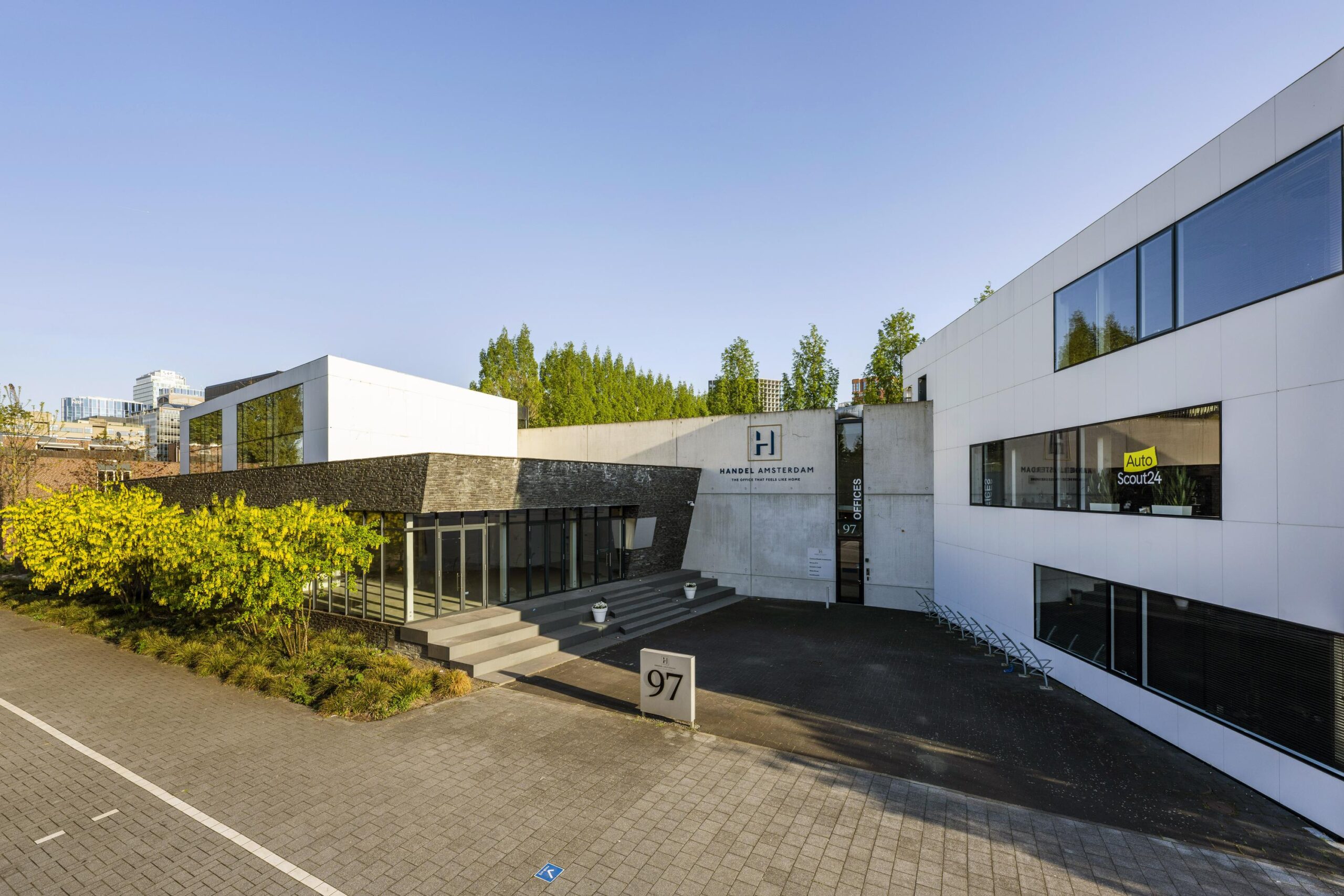 Modern kantoorgebouw aan de Fred. Roeskestraat 97 in Amsterdam met het logo van Handel Amsterdam en AutoScout24 zichtbaar op de gevel.